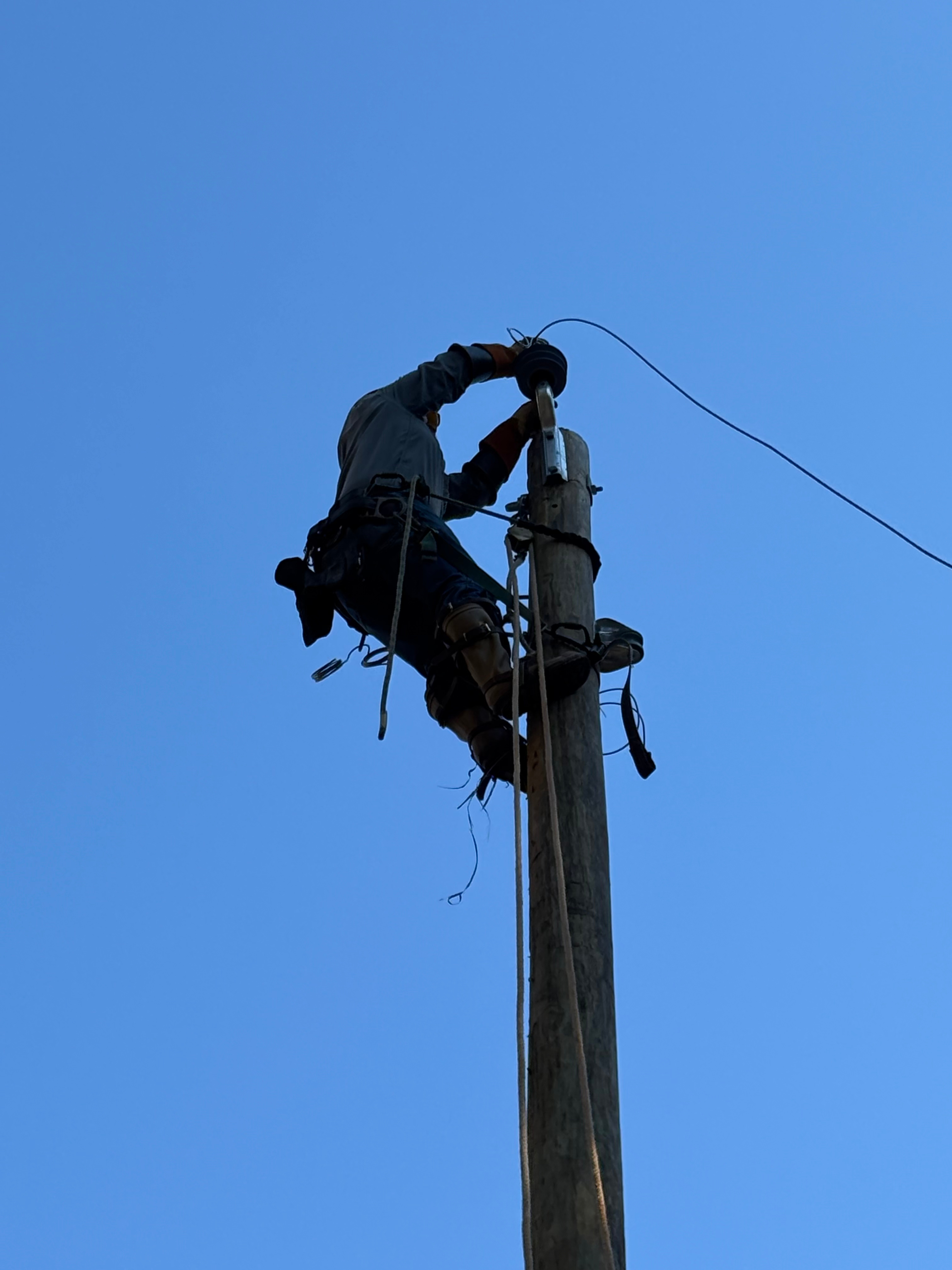 lineworker working on electric pole