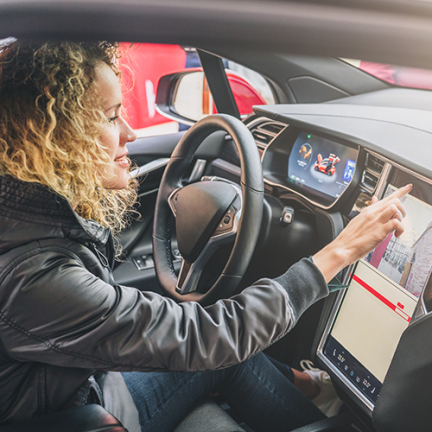 Woman driving EV touching screen