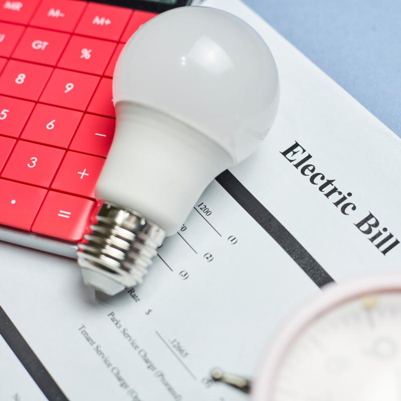 An electric bill, led light bulb and calculator