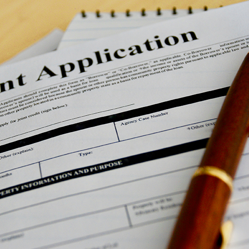 A paper grant application and a pen